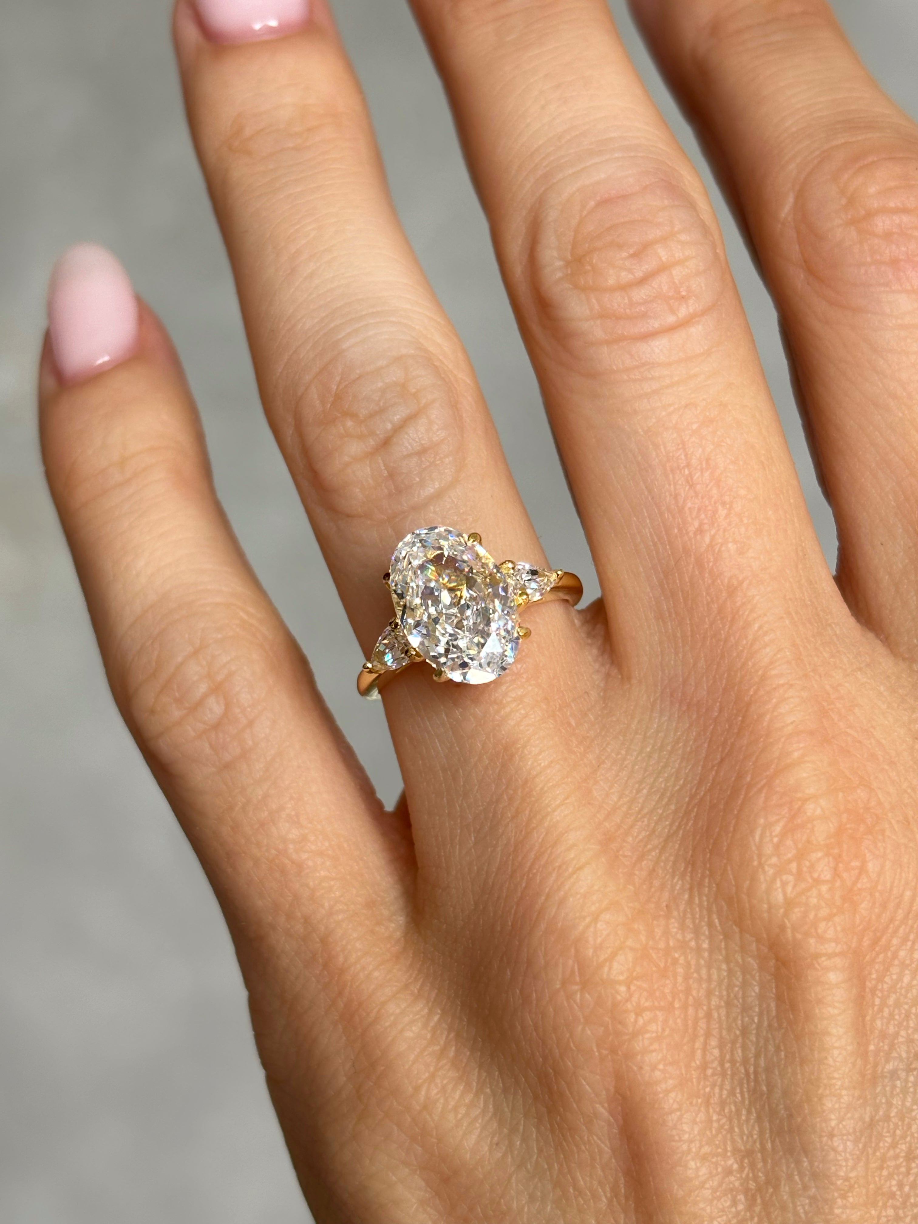 Oval stone ring with pear-cut side stones